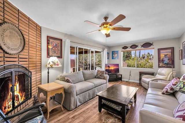 8160 Cholla Ave, Yucca Valley, CA 92284 - living area featuring a ceiling fan, a brick fireplace, and wood finished floors