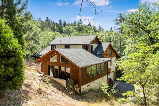 77 Park Dr, Running Springs, CA 92382 - rear view of property with roof with shingles, driveway, a garage, and a wooded view