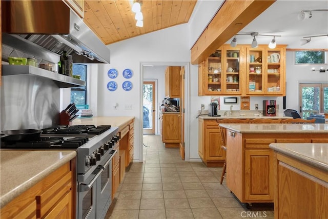 77 Park Dr, Running Springs, CA 92382 - kitchen with range with two ovens, light tile patterned floors, light countertops, lofted ceiling, and glass insert cabinets