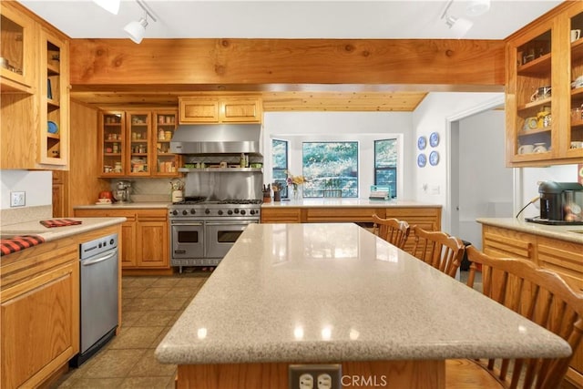 77 Park Dr, Running Springs, CA 92382 - kitchen with under cabinet range hood, double oven range, track lighting, a kitchen island, and glass insert cabinets