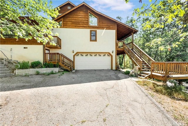 77 Park Dr, Running Springs, CA 92382 - view of home's exterior featuring stairway, stucco siding, driveway, and a garage