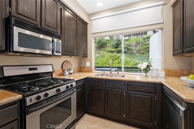 25066 El Carrizo, Laguna Niguel, CA 92677 - kitchen with appliances with stainless steel finishes, dark brown cabinetry, light tile patterned floors, light stone countertops, and recessed lighting