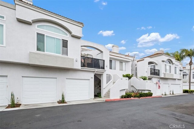 25066 El Carrizo, Laguna Niguel, CA 92677 - multi unit property featuring a chimney, stucco siding, a garage, and stairs