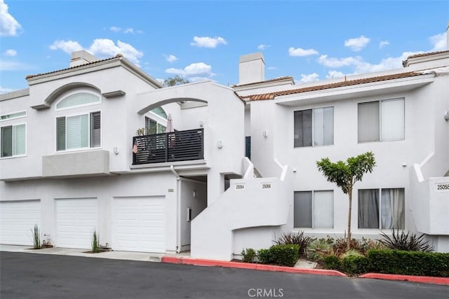 25066 El Carrizo, Laguna Niguel, CA 92677 - view of front of house featuring a chimney, stucco siding, an attached garage, and a balcony
