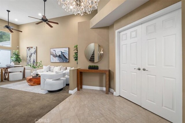 25066 El Carrizo, Laguna Niguel, CA 92677 - living room with ceiling fan, light tile patterned floors, a chandelier, and a towering ceiling