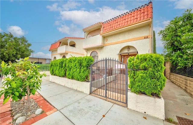 215 N Maple Ave Unit A, Montebello, CA 90640 - mediterranean / spanish home with a tile roof, a fenced front yard, a gate, and stucco siding
