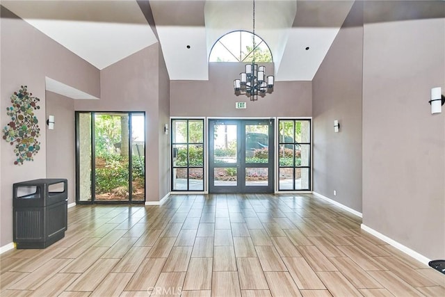 4280 Via Arbolada Unit 338, Los Angeles, CA 90042 - unfurnished living room with a towering ceiling, a chandelier, healthy amount of natural light, and wood finish floors