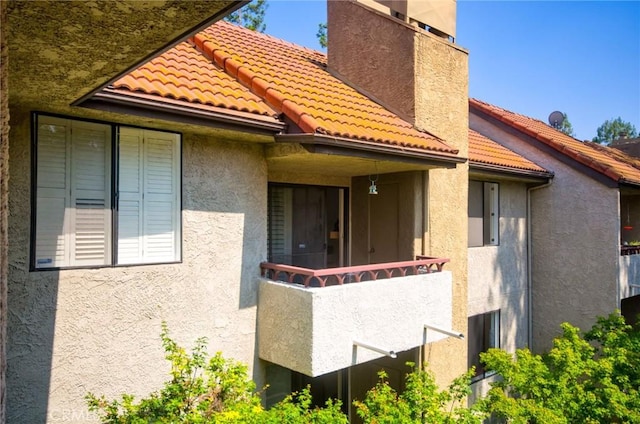 4280 Via Arbolada Unit 338, Los Angeles, CA 90042 - back of house with stucco siding, a tile roof, a chimney, and a balcony