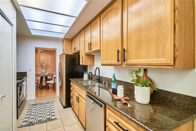 4280 Via Arbolada Unit 338, Los Angeles, CA 90042 - kitchen featuring stainless steel appliances, light tile patterned floors, and dark stone countertops