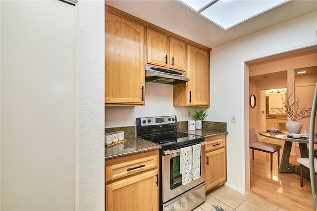 4280 Via Arbolada Unit 338, Los Angeles, CA 90042 - kitchen with stainless steel electric stove, under cabinet range hood, dark stone countertops, and light tile patterned floors