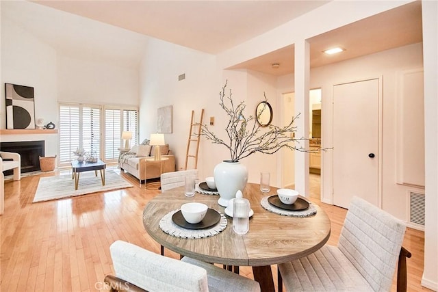 4280 Via Arbolada Unit 338, Los Angeles, CA 90042 - dining space with light wood-style floors, a fireplace, and a high ceiling