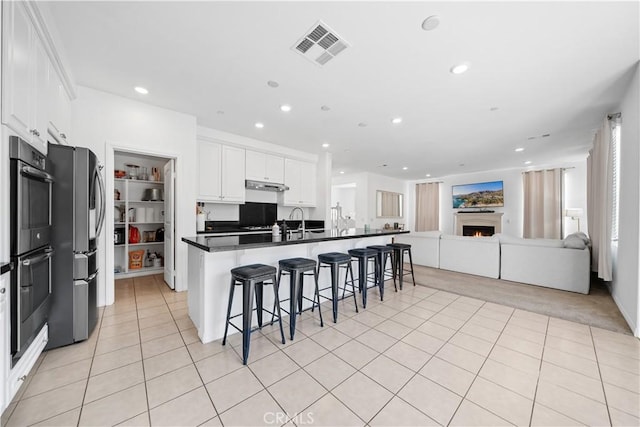13126 Flagstaff Dr, Rancho Cucamonga, CA 91739 - kitchen with appliances with stainless steel finishes, open floor plan, a kitchen breakfast bar, white cabinetry, and dark countertops
