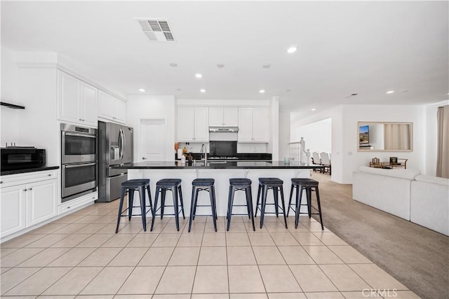 13126 Flagstaff Dr, Rancho Cucamonga, CA 91739 - kitchen with stainless steel appliances, open floor plan, dark countertops, recessed lighting, and a breakfast bar