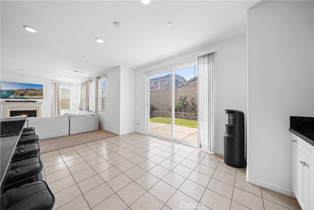 13126 Flagstaff Dr, Rancho Cucamonga, CA 91739 - unfurnished living room featuring plenty of natural light, a warm lit fireplace, recessed lighting, and light tile patterned flooring