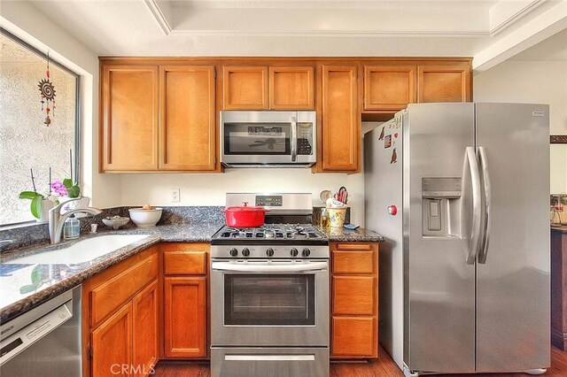 1531 Corte Caballo Unit 33, Upland, CA 91786 - kitchen featuring stainless steel appliances, brown cabinetry, dark stone countertops, and dark wood-style floors