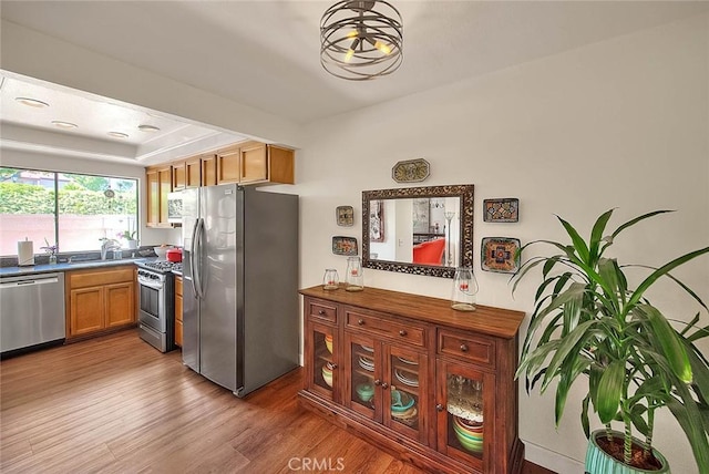 1531 Corte Caballo Unit 33, Upland, CA 91786 - kitchen with stainless steel appliances, wood finished floors, and dark countertops