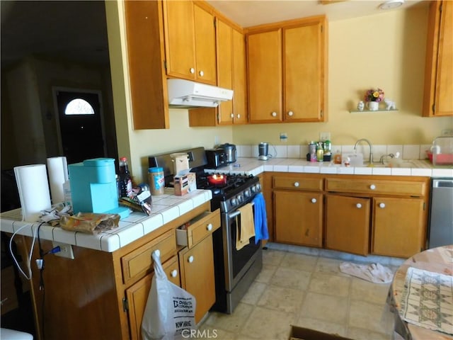 8372 Dogwood Ave, California City, CA 93505 - kitchen featuring under cabinet range hood, stainless steel appliances, brown cabinets, and a peninsula