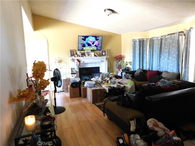 8372 Dogwood Ave, California City, CA 93505 - living area featuring wood finished floors, lofted ceiling, and a tiled fireplace