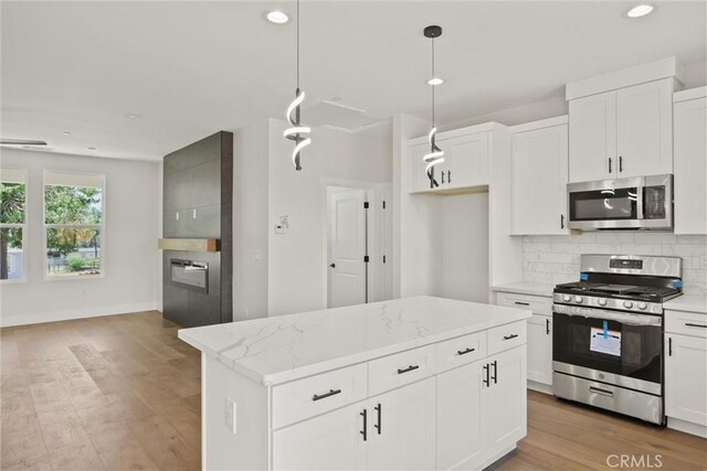 1761 Drayer Dr, Paradise, CA 95969 - kitchen with stainless steel appliances, decorative backsplash, recessed lighting, light wood-style floors, and white cabinetry
