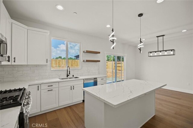 1761 Drayer Dr, Paradise, CA 95969 - kitchen with appliances with stainless steel finishes, recessed lighting, wood finished floors, tasteful backsplash, and a center island