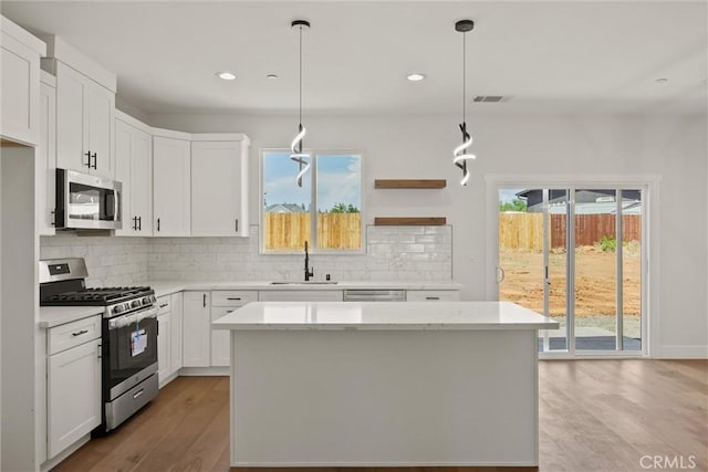 1761 Drayer Dr, Paradise, CA 95969 - kitchen with appliances with stainless steel finishes, light wood-style floors, tasteful backsplash, white cabinetry, and recessed lighting