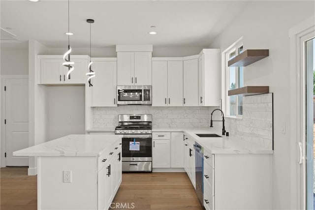 1761 Drayer Dr, Paradise, CA 95969 - kitchen with stainless steel appliances, open shelves, light wood-style flooring, a kitchen island, and white cabinets