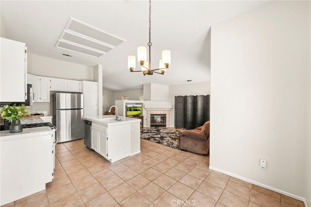 33546 Maplewood Ct, Temecula, CA 92592 - kitchen featuring stainless steel appliances, open floor plan, white cabinetry, light tile patterned floors, and lofted ceiling