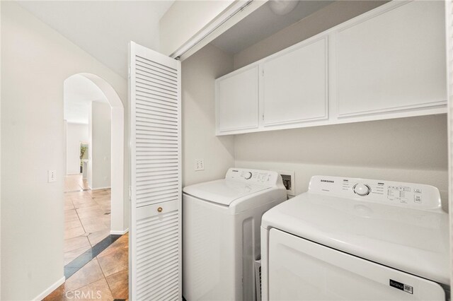 33546 Maplewood Ct, Temecula, CA 92592 - laundry room featuring washer and dryer, cabinet space, light tile patterned floors, and arched walkways