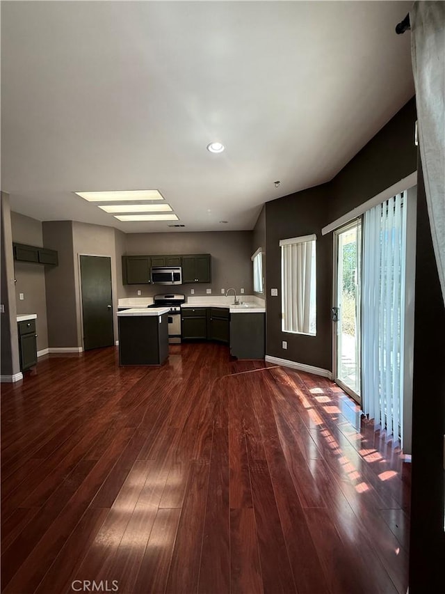 13590 Fox Point Rd, Victorville, CA 92392 - kitchen featuring appliances with stainless steel finishes, light countertops, dark wood-style floors, and a center island