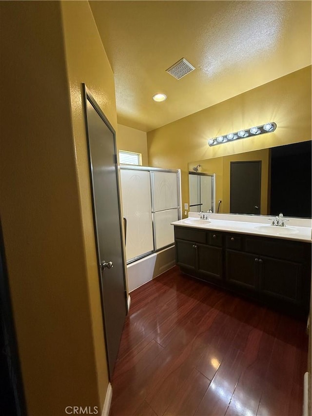 13590 Fox Point Rd, Victorville, CA 92392 - full bath featuring double vanity, wood finished floors, and enclosed tub / shower combo