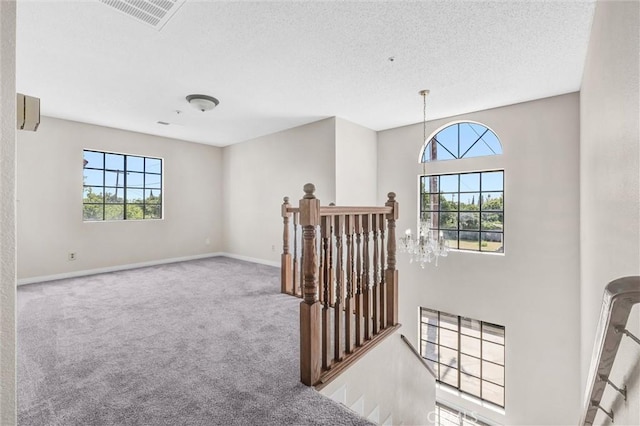 10102 Rio Hondo, El Monte, CA 91733 - corridor featuring an upstairs landing, plenty of natural light, carpet flooring, a textured ceiling, and a chandelier