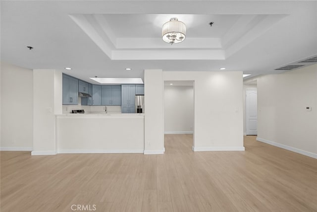 4348 Mammoth Ave Unit 102, Sherman Oaks, CA 91423 - unfurnished living room featuring a raised ceiling, light wood-style flooring, and recessed lighting