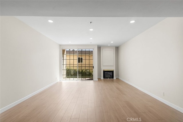 4348 Mammoth Ave Unit 102, Sherman Oaks, CA 91423 - unfurnished living room featuring a glass covered fireplace, light wood-style floors, and recessed lighting