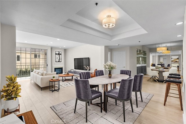 4348 Mammoth Ave Unit 102, Sherman Oaks, CA 91423 - dining room featuring light wood-style floors, recessed lighting, a tray ceiling, and a glass covered fireplace