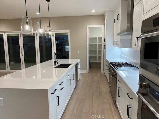 22046 Fig Tree Ln, Chatsworth, CA 91311 - kitchen featuring an island with sink, wall chimney range hood, light wood-style flooring, light countertops, and recessed lighting
