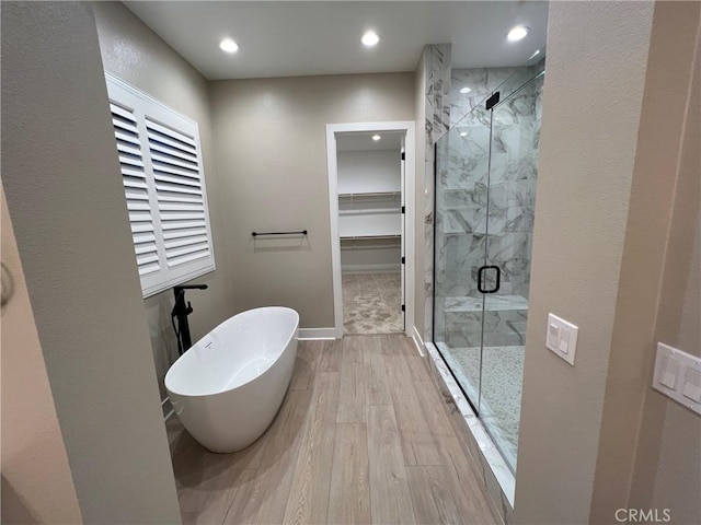 22046 Fig Tree Ln, Chatsworth, CA 91311 - bathroom with a marble finish shower, a freestanding tub, a walk in closet, wood finished floors, and recessed lighting
