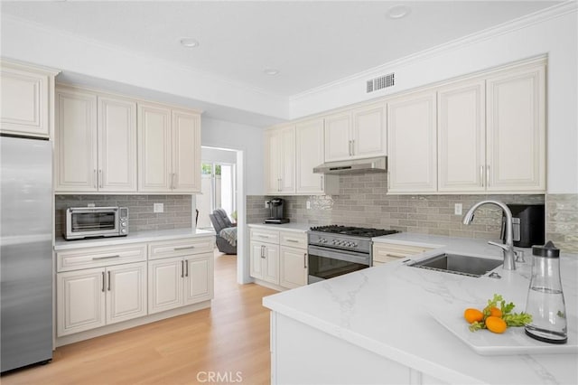 4324 Park Verdi, Calabasas, CA 91302 - kitchen with stainless steel appliances, under cabinet range hood, light wood-type flooring, tasteful backsplash, and ornamental molding
