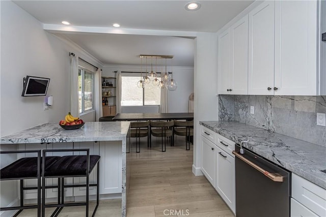 9418 Via Patricia Unit 30, Burbank, CA 91504 - kitchen with dishwashing machine, white cabinets, a kitchen breakfast bar, light stone counters, and light wood-style floors