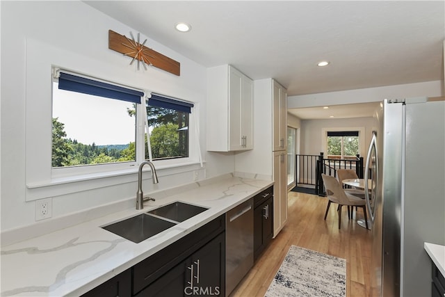 582 Sunset View Rd, Twin Peaks, CA 92391 - kitchen featuring appliances with stainless steel finishes, white cabinets, dark cabinetry, light wood-style flooring, and light stone counters