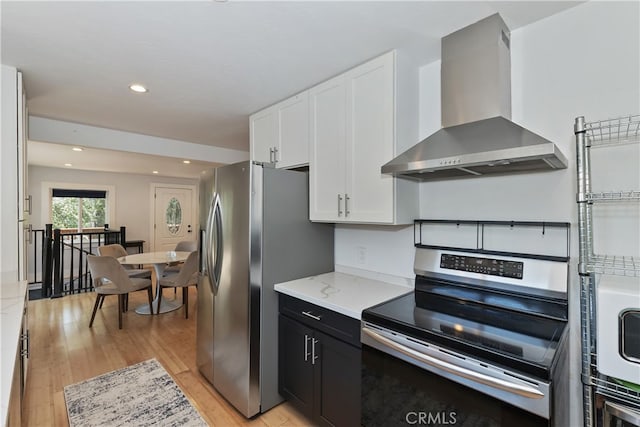 582 Sunset View Rd, Twin Peaks, CA 92391 - kitchen featuring wall chimney exhaust hood, appliances with stainless steel finishes, white cabinetry, light wood-style floors, and light stone counters