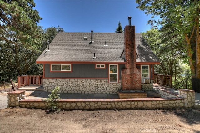 582 Sunset View Rd, Twin Peaks, CA 92391 - back of house with a shingled roof, a chimney, stone siding, and cooling unit