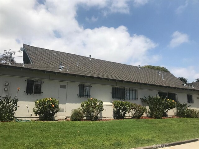 3666 Cedar Ave, Long Beach, CA 90807 - rear view of property featuring a shingled roof, stucco siding, and a lawn