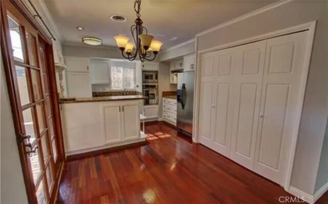 3666 Cedar Ave, Long Beach, CA 90807 - kitchen with appliances with stainless steel finishes, a chandelier, dark countertops, white cabinetry, and dark wood-type flooring