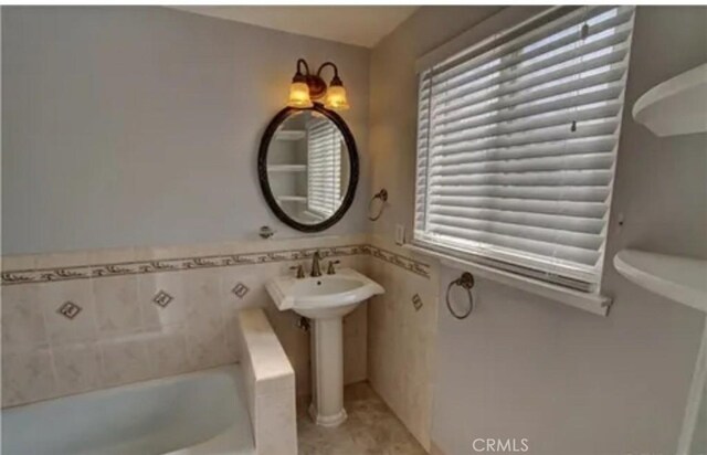 3666 Cedar Ave, Long Beach, CA 90807 - bathroom featuring a bath, tile walls, a wainscoted wall, and tile patterned floors