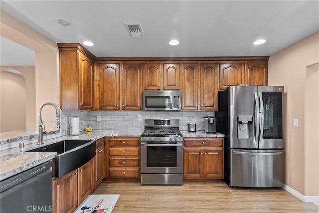 40139 15th St W, Palmdale, CA 93551 - kitchen featuring stainless steel appliances, light stone countertops, arched walkways, decorative backsplash, and recessed lighting