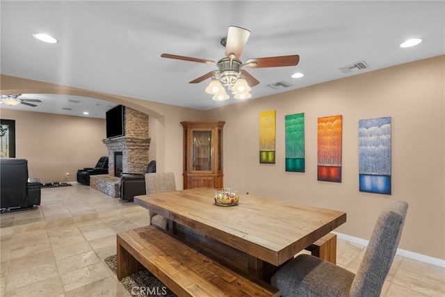40139 15th St W, Palmdale, CA 93551 - dining room featuring a ceiling fan, a stone fireplace, recessed lighting, and arched walkways