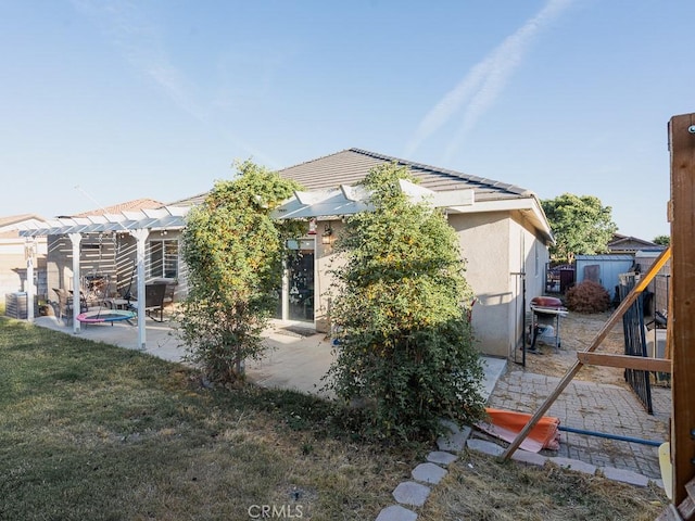 3031 E Lingard St, Lancaster, CA 93535 - view of side of property with a patio area, a pergola, stucco siding, and a yard