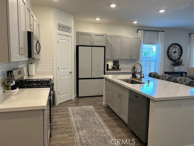 1658 Almondwood Dr, Orland, CA 95963 - kitchen with appliances with stainless steel finishes, dark wood-type flooring, light countertops, tasteful backsplash, and recessed lighting