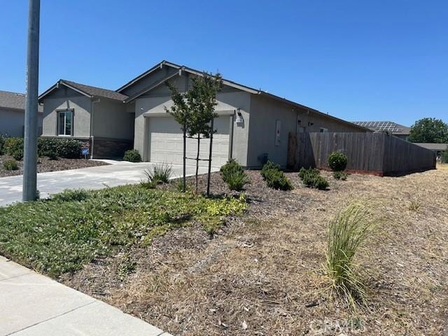 1658 Almondwood Dr, Orland, CA 95963 - view of side of home featuring stucco siding, an attached garage, and driveway
