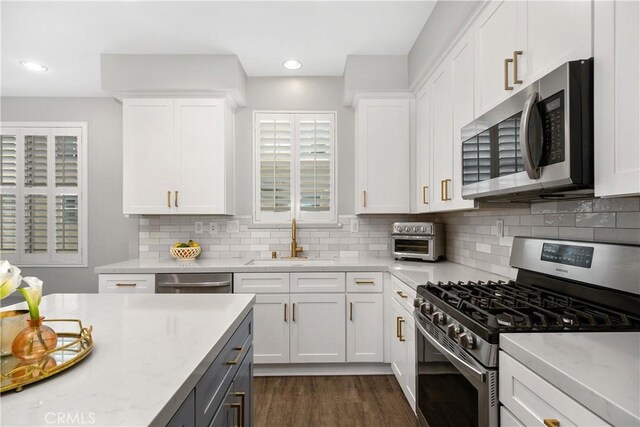 13131 Park Pl Unit 102, Hawthorne, CA 90250 - kitchen with stainless steel appliances, white cabinetry, backsplash, dark wood-style flooring, and recessed lighting